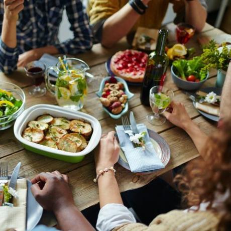 vrienden eten aan een houten tafel