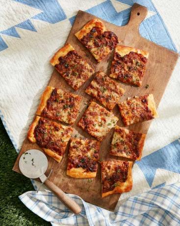 Franse ui flatbread op een houten snijplank op een picknickdeken