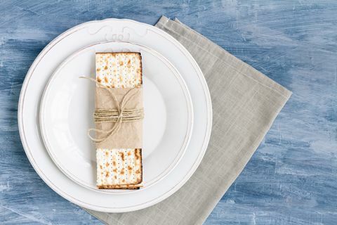 witte plaat met matzah of matza op een vintage tafelachtergrond gepresenteerd als een paasfeest of maaltijd