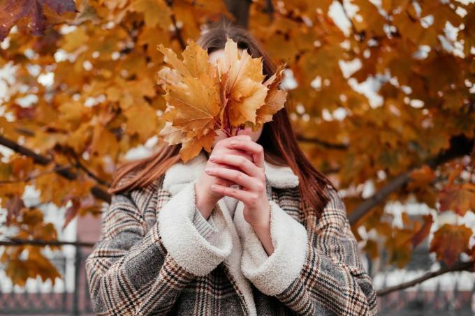 vrouw met herfstbladeren