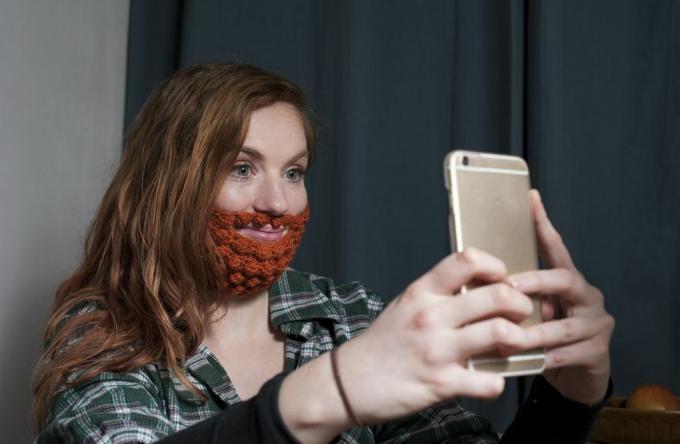 vrouw met een rode gehaakte baard die een selfie neemt voor de dag van heilige patrick