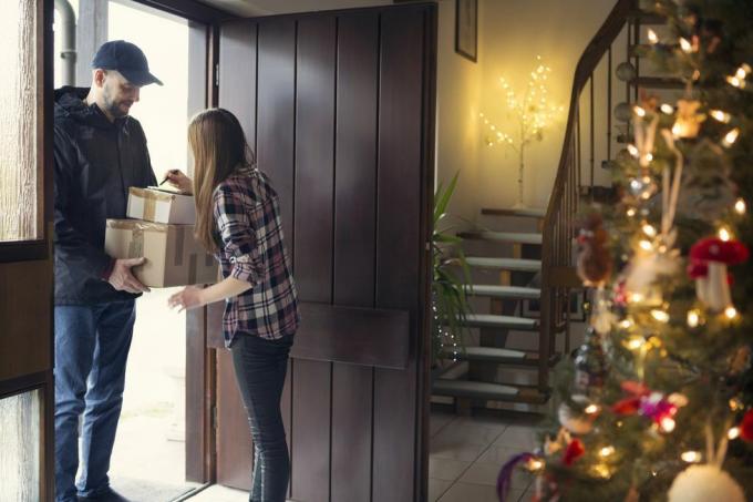 tiener ontvangt kerstpakketten afgeleverd door postbode