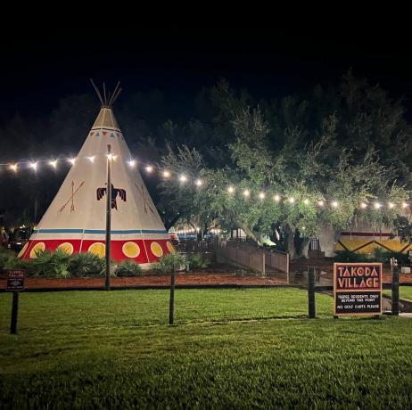 luxe tipi met de nachtelijke hemel en lichtslingers op de achtergrond