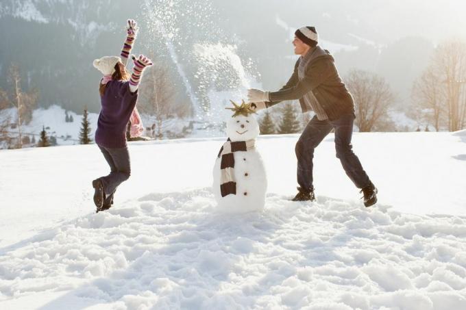 paar sneeuwpop maken en spelen in de sneeuw