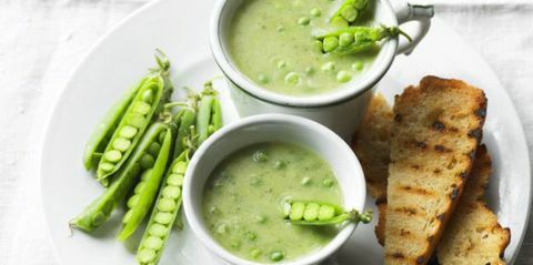 Erwtensoep met courgette, knoflook en basilicum in witte kom met toast