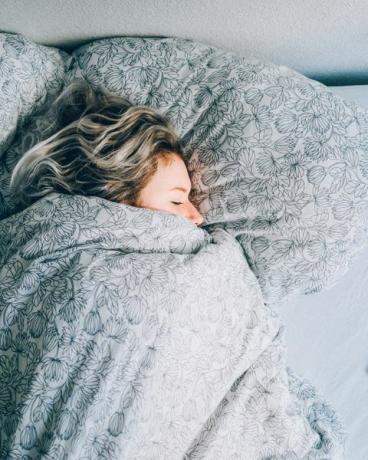 hoge hoekmening van vrouw die op bed slaapt