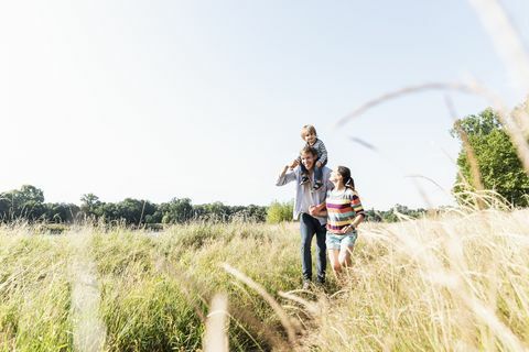 Gelukkige familie wandelen aan de rivier op een mooie zomerdag