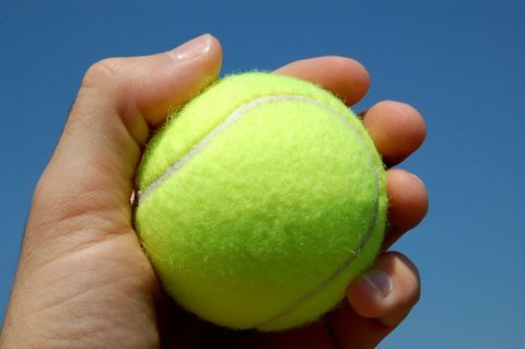 In hand dichte omhooggaand van de tennisbal
