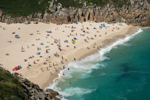 Mensen genieten van het goede weer op Porthcurno Beach in de buurt van Penzance 