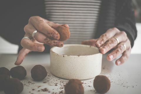 vrouw die zelfgemaakte chocoladetruffels maakt