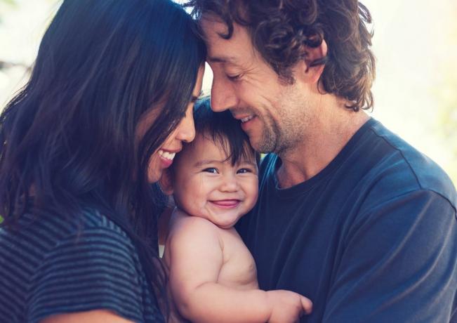 een negen maanden oude baby die graag tussen haar moeder en vader is