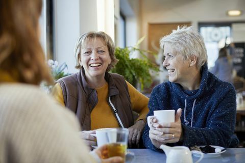 lesbisch koppel en volwassen dochter koffie drinken en praten in café