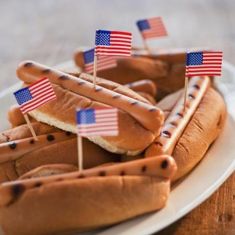 kleine Amerikaanse vlaggen in gegrilde hotdogs op broodjes