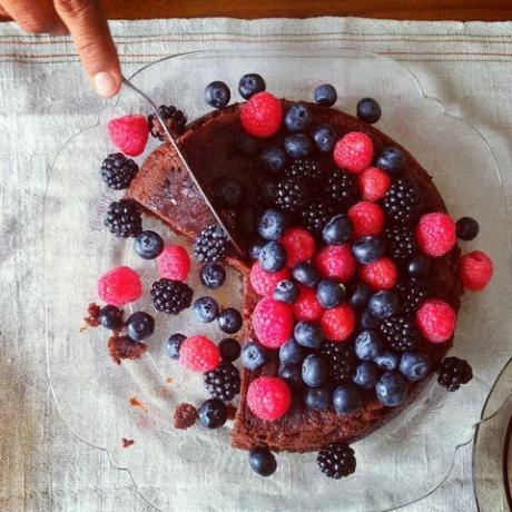 Cake met bessen op wordt gesneden met mes - geklede tafel