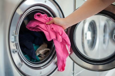 vrouw die overhemd in wasmachine doet