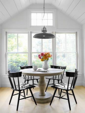 een neutrale eetkamer met zwart gelakte Windsor stoelen