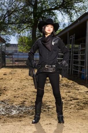 Japanse vrouw in volledig zwart cowgirl-kostuum