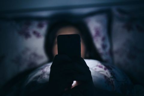 vrouw in bed telefoon