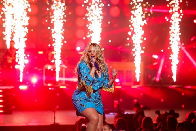 miranda lambert treedt op in las vegas in bijpassende blauwe minirok, oogverblindende top en netkous met vuurwerk dat achter haar afgaat