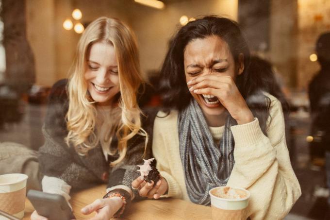 vriendinnen met smartphone in coffeeshop