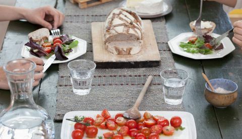 Sluit omhoog van paar dat lunch heeft bij lijst met tomaten en brood