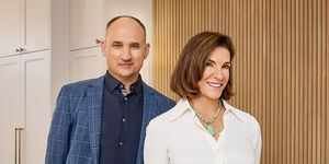 gastheren hilary farr en david visentin staan ​​glimlachend in de open keuken